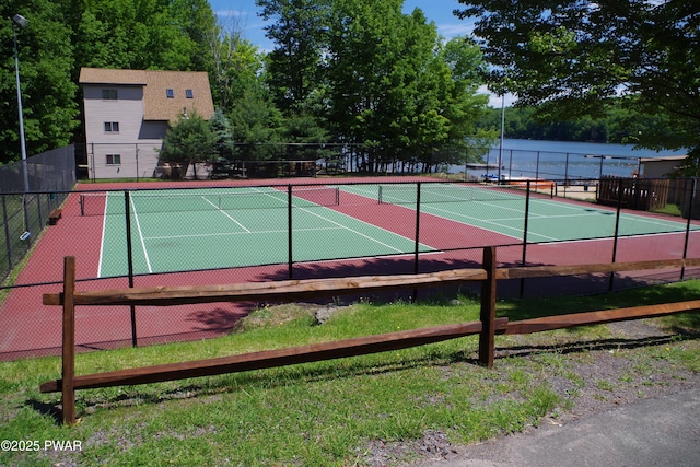 view of tennis court with a water view