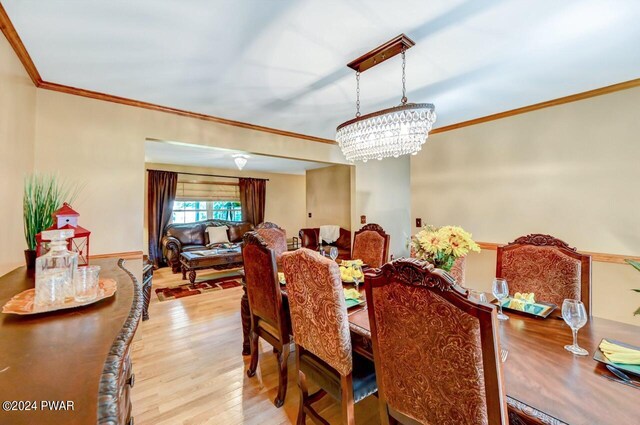 dining space with a chandelier, light hardwood / wood-style floors, and ornamental molding