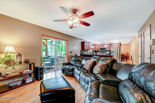 living room with ceiling fan and light hardwood / wood-style floors