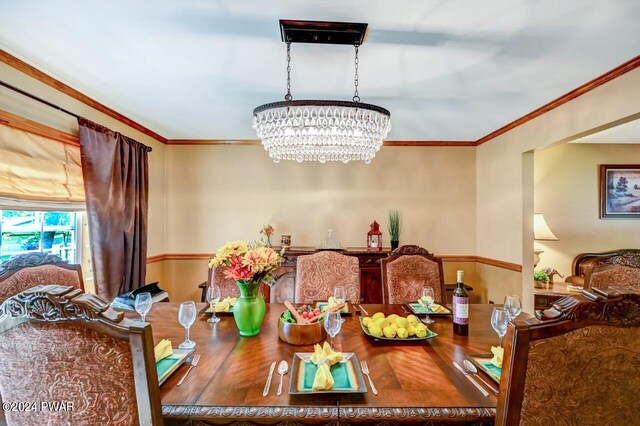 dining area featuring ornamental molding and a chandelier