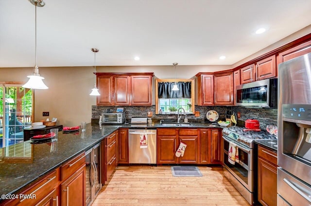 kitchen featuring plenty of natural light, sink, hanging light fixtures, and appliances with stainless steel finishes