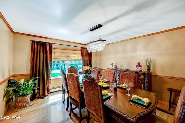 dining area with crown molding, light hardwood / wood-style flooring, a baseboard radiator, and an inviting chandelier