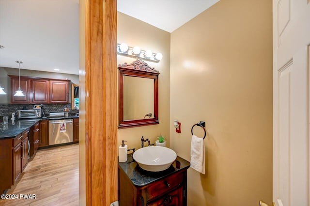 bathroom featuring backsplash, vanity, and wood-type flooring