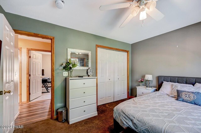 carpeted bedroom with ceiling fan and a closet