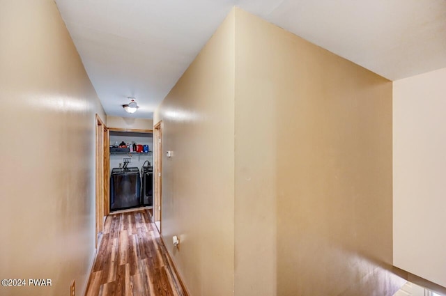 hallway with washer and clothes dryer and hardwood / wood-style flooring