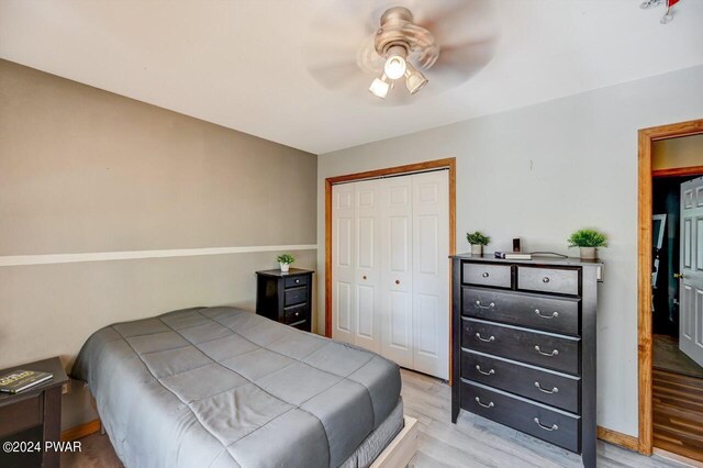 bedroom featuring light wood-type flooring, a closet, and ceiling fan