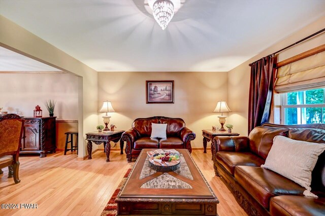 living room with light hardwood / wood-style flooring and an inviting chandelier