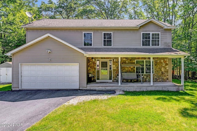 front of property with a porch, a garage, and a front lawn