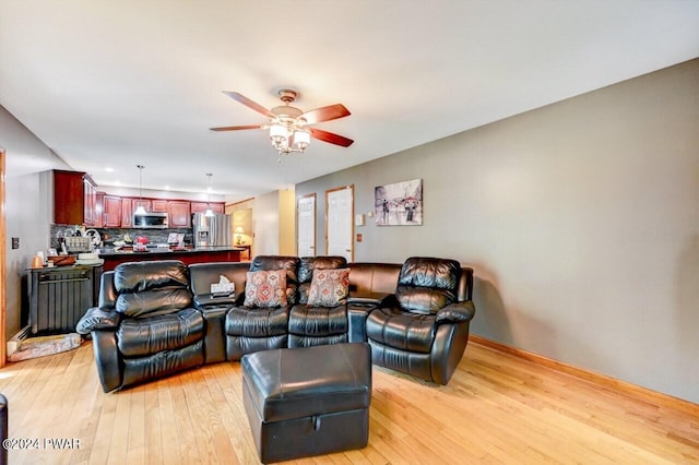 living room featuring light hardwood / wood-style floors and ceiling fan