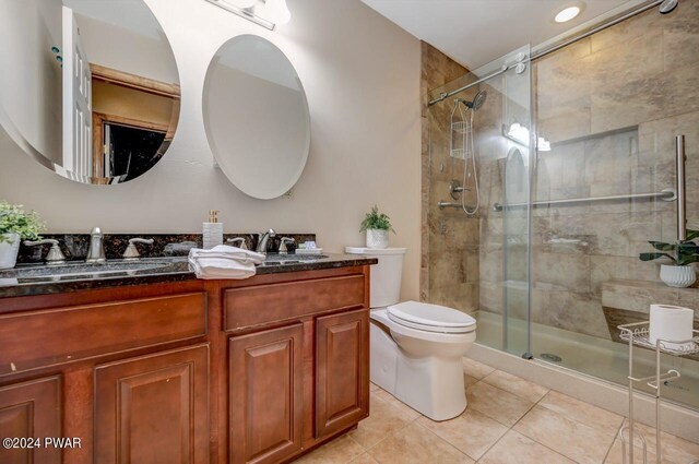 bathroom with tile patterned floors, vanity, toilet, and walk in shower