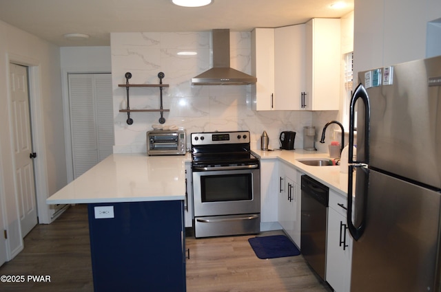 6372 Baltic Ave, Tobyhanna, PA 18466 - kitchen with stainless steel appliances, wall chimney range hood, a sink, a peninsula, and open shelves