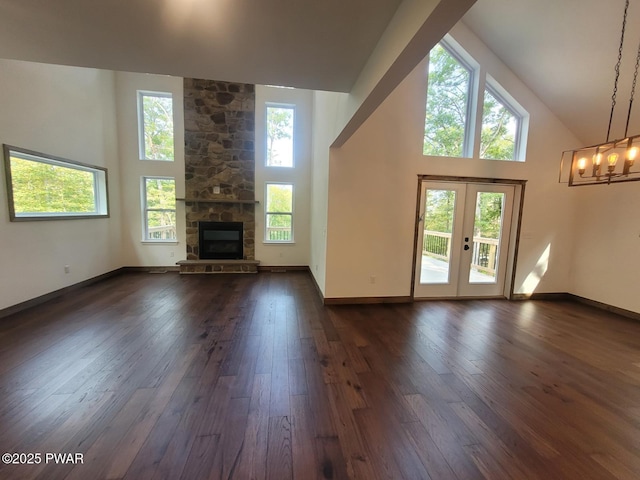 101 Maple Leaf Rd, Lackawaxen, PA 18435 - unfurnished living room featuring an inviting chandelier, a fireplace, high vaulted ceiling, french doors, and dark wood-type flooring