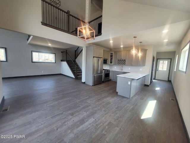 101 Maple Leaf Rd, Lackawaxen, PA 18435 - kitchen with glass insert cabinets, dark wood-style flooring, premium appliances, a peninsula, and a towering ceiling