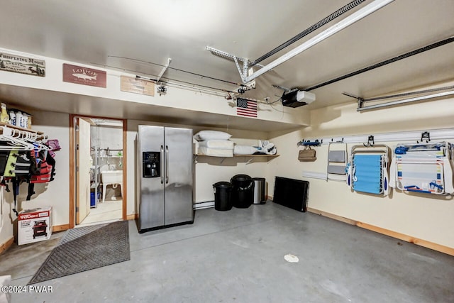 garage with stainless steel fridge and a garage door opener