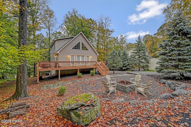 back of property featuring a fire pit and a deck