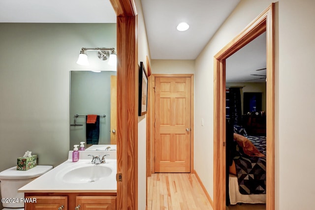 bathroom featuring hardwood / wood-style flooring, vanity, and toilet