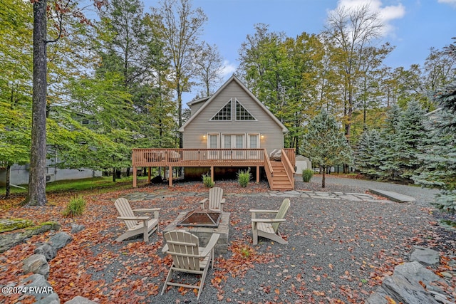 back of house featuring a wooden deck and a fire pit