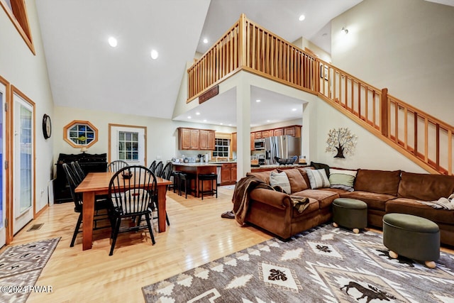 living room featuring light hardwood / wood-style flooring and high vaulted ceiling