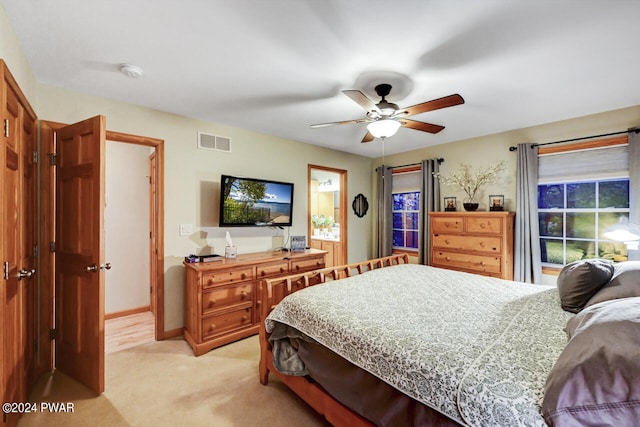 carpeted bedroom with connected bathroom and ceiling fan