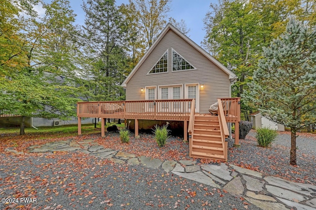 back of property featuring a wooden deck and a storage unit