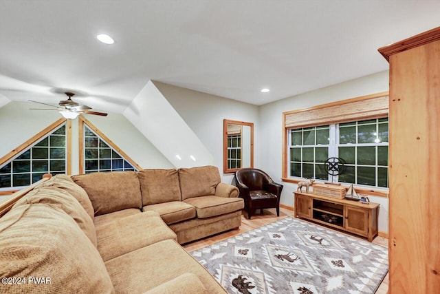 living room featuring ceiling fan, light wood-type flooring, and lofted ceiling