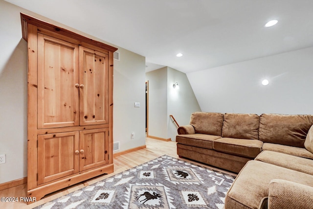 living room with light hardwood / wood-style flooring and lofted ceiling