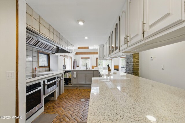 20 Chuck Foster Dr, Hawley, PA 18428 - kitchen with stainless steel oven, a peninsula, a sink, gray cabinetry, and light stone counters