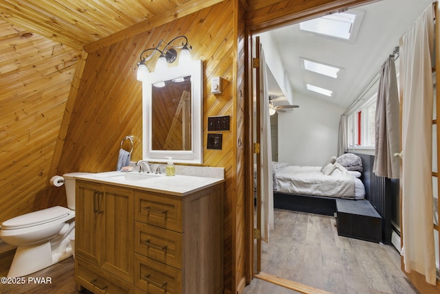 20 Chuck Foster Dr, Hawley, PA 18428 - bathroom with a skylight, vaulted ceiling, wooden walls, toilet, and vanity