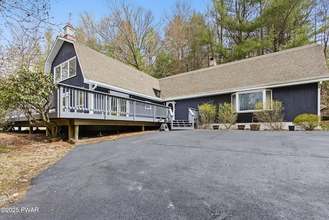 20 Chuck Foster Dr, Hawley, PA 18428 - view of front of property featuring a chimney, roof with shingles, a wooden deck, and a gambrel roof