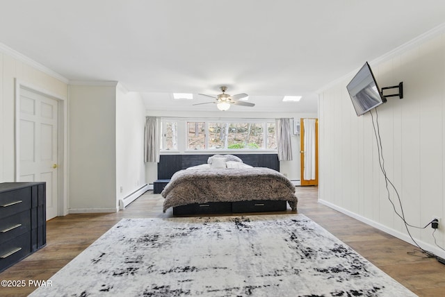 20 Chuck Foster Dr, Hawley, PA 18428 - bedroom with baseboard heating, ornamental molding, a skylight, wood finished floors, and baseboards