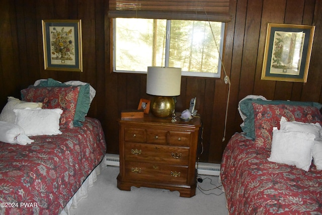 bedroom with a baseboard radiator, multiple windows, and wooden walls