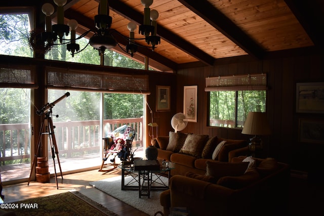 living room with wood ceiling, lofted ceiling with beams, light hardwood / wood-style flooring, an inviting chandelier, and wood walls