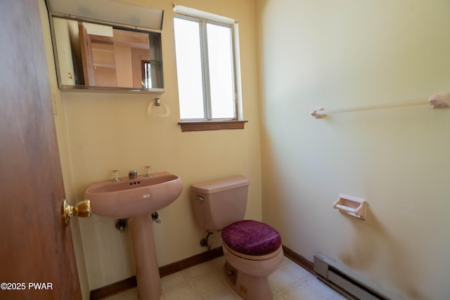 bathroom with a sink, tile patterned floors, baseboards, a baseboard heating unit, and toilet