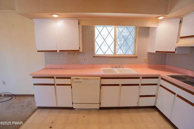 kitchen with white dishwasher, a sink, backsplash, and light countertops