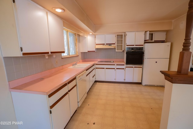 kitchen with white appliances, white cabinets, under cabinet range hood, and a sink