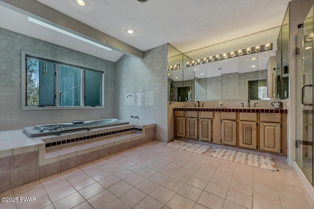 bathroom featuring tile patterned floors, separate shower and tub, vanity, and tile walls