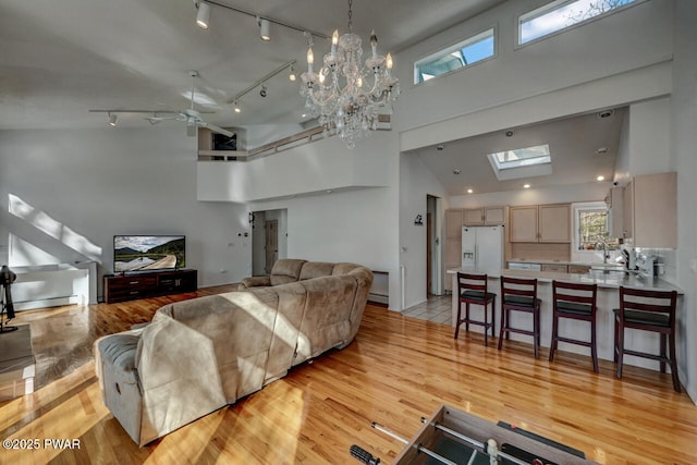 living room with a high ceiling, a baseboard radiator, and light hardwood / wood-style flooring