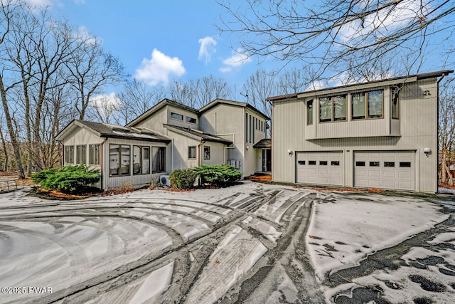 view of front of home featuring a garage and a sunroom