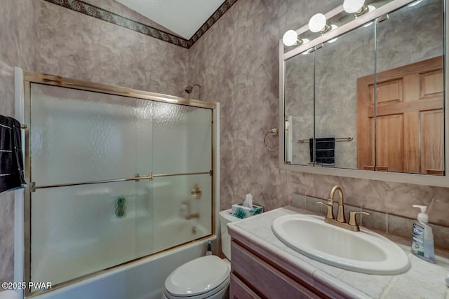 full bathroom featuring vanity, backsplash, shower / bath combination with glass door, and toilet