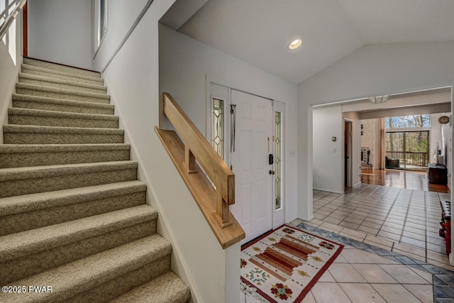 entryway with light tile patterned flooring and vaulted ceiling