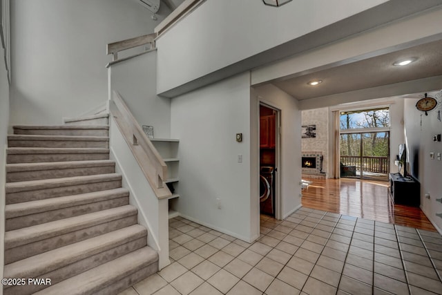 staircase featuring tile patterned floors and a brick fireplace