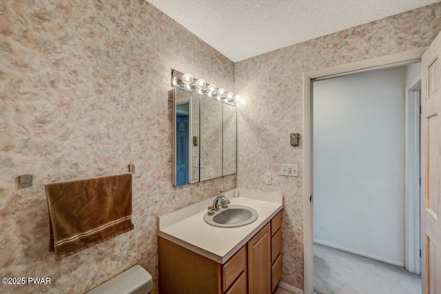 bathroom featuring vanity, a textured ceiling, and toilet