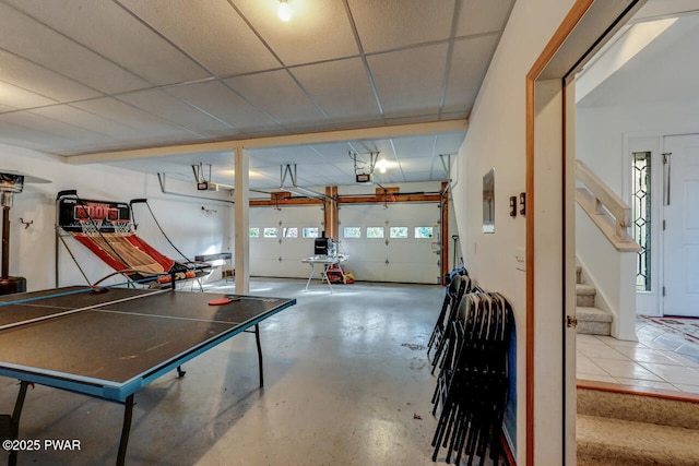 playroom featuring concrete floors and a drop ceiling