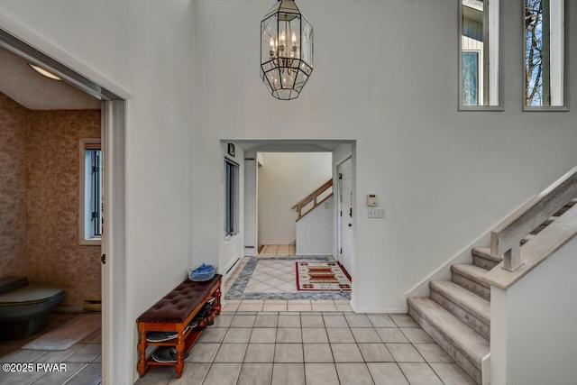 tiled entryway featuring an inviting chandelier