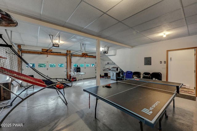 game room featuring a paneled ceiling, electric panel, and concrete floors