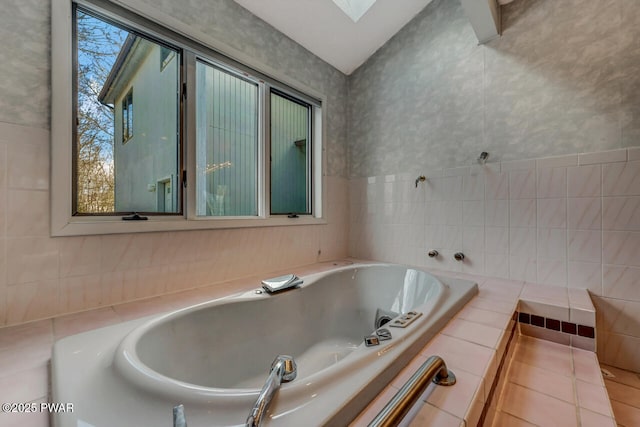 bathroom featuring tiled tub and tile walls