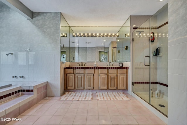 bathroom with tile walls, vanity, tile patterned flooring, and plus walk in shower