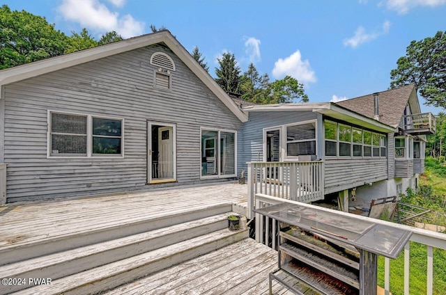 rear view of house featuring a deck and a sunroom