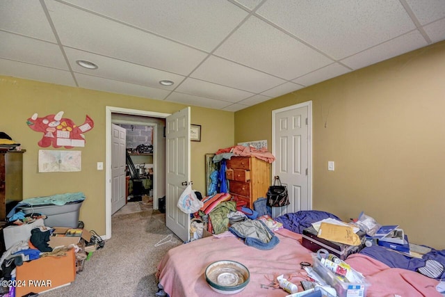 bedroom with a drop ceiling and carpet floors