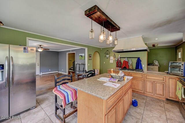 kitchen with a breakfast bar, ceiling fan, a baseboard heating unit, stainless steel fridge with ice dispenser, and a kitchen island